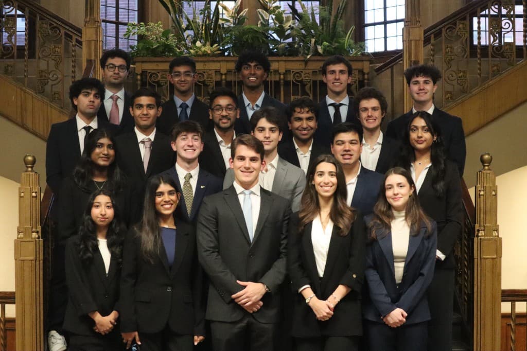 The Anvil team in business attire, posed on an ornate wooden staircase.